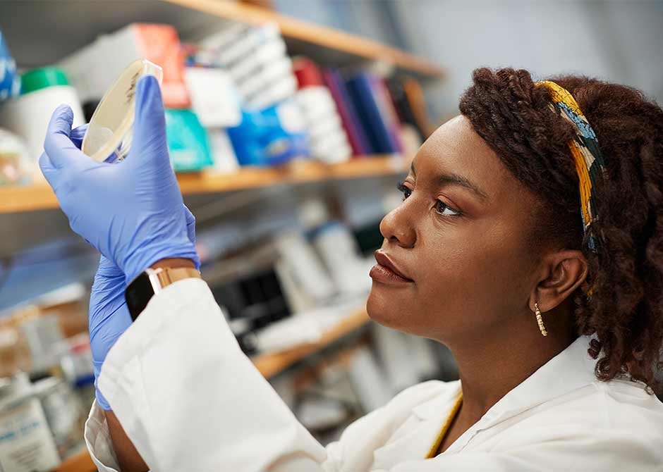 Medical student Aliyah Bennett examining a  petri dish