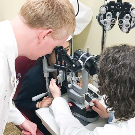 Ophthalmology resident looking through microscope