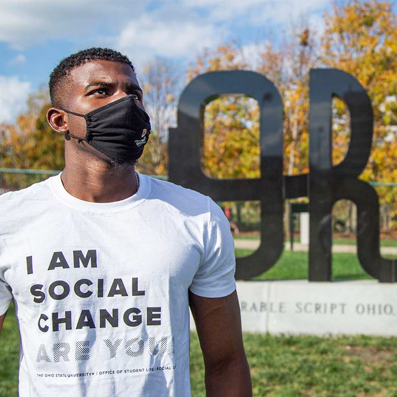 Student wearing a mask and a shirt saying, 'I am social change.'