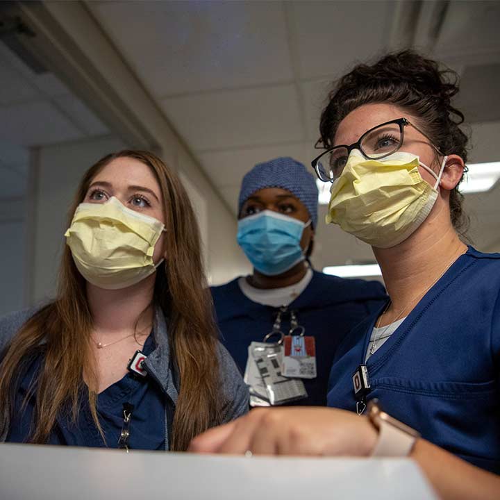 Three medical residents wearing masks