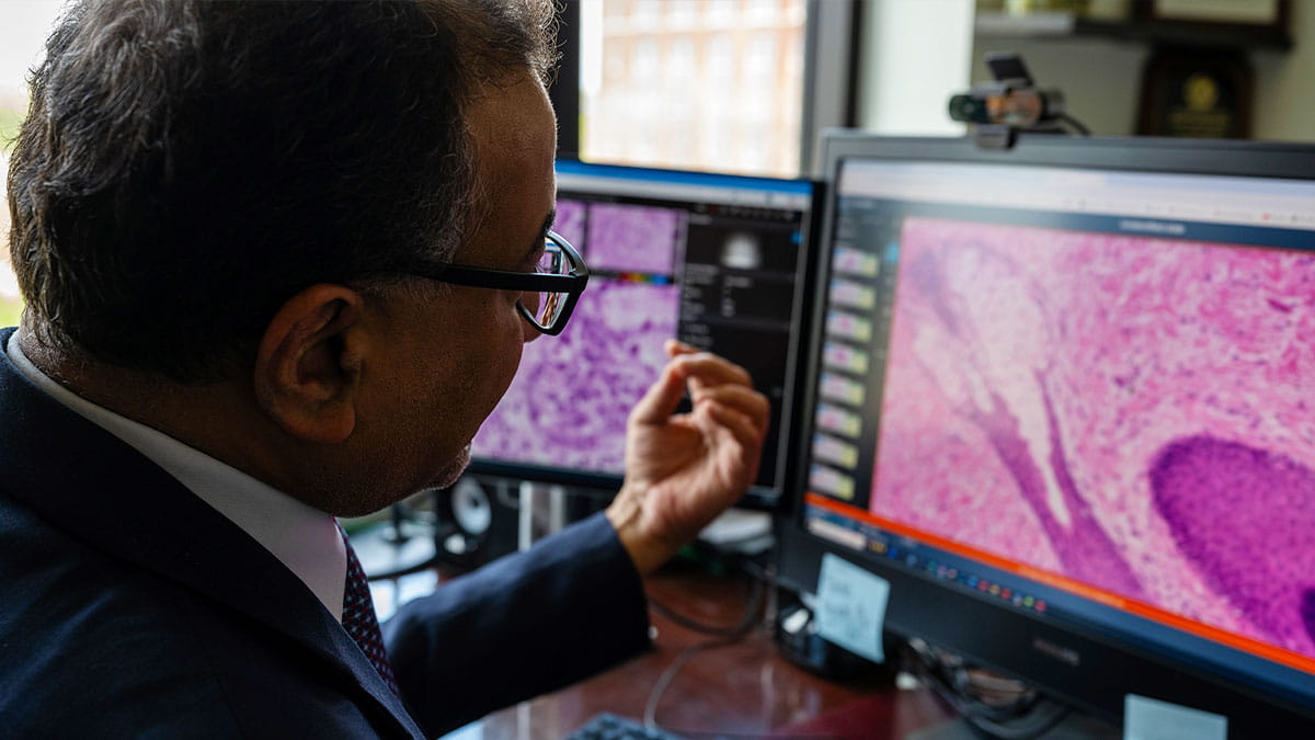 Anil Parwani looking at a scan on his computer. 