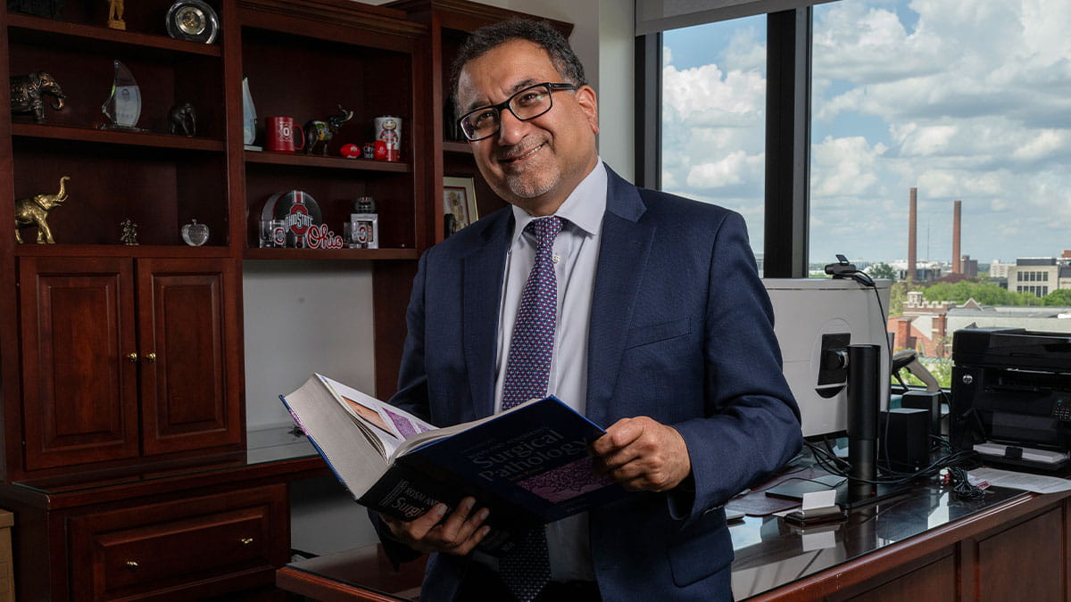 Anil Parwani holding book in office. 