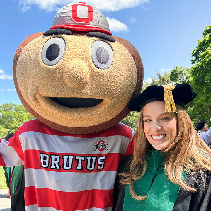 Dr. Moore and Brutus Buckeye smiling at commencement. 