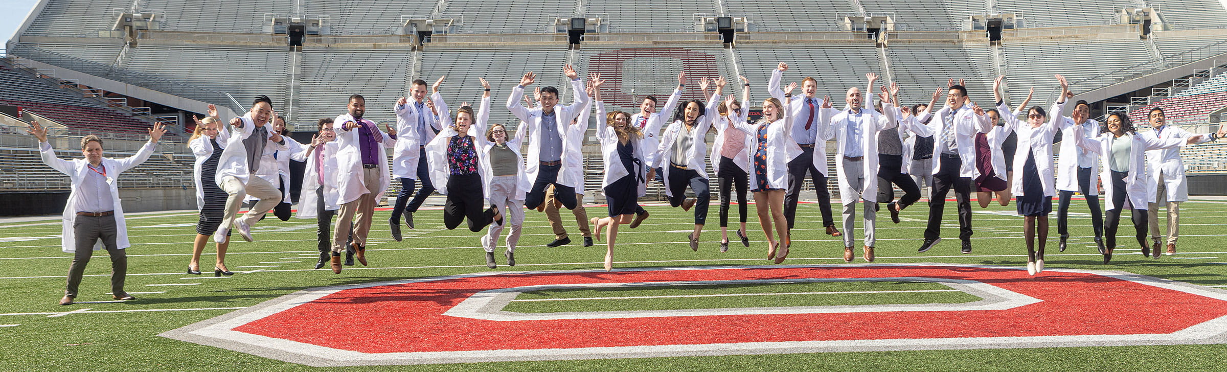 First year residents in a jump at the Ohio State stadium.