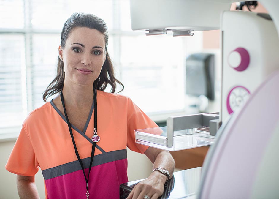 Nurse standing next to mammogram machine
