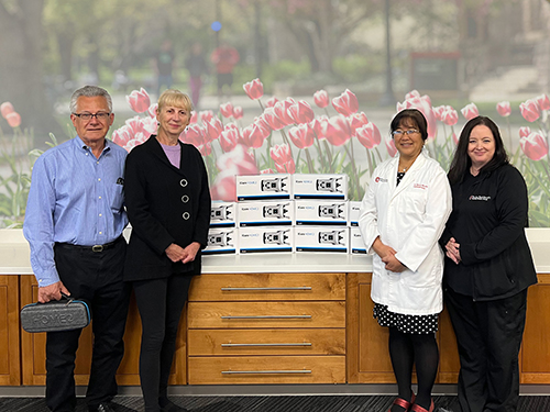 people pose for photo with donated equipment