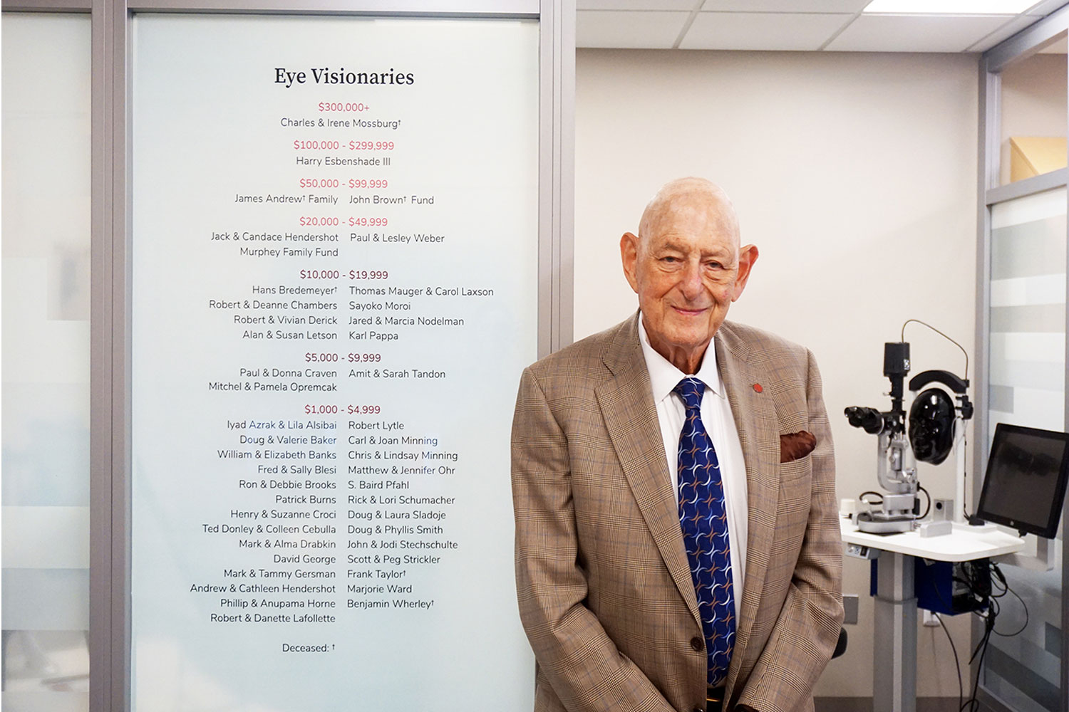 man in front of donor wall