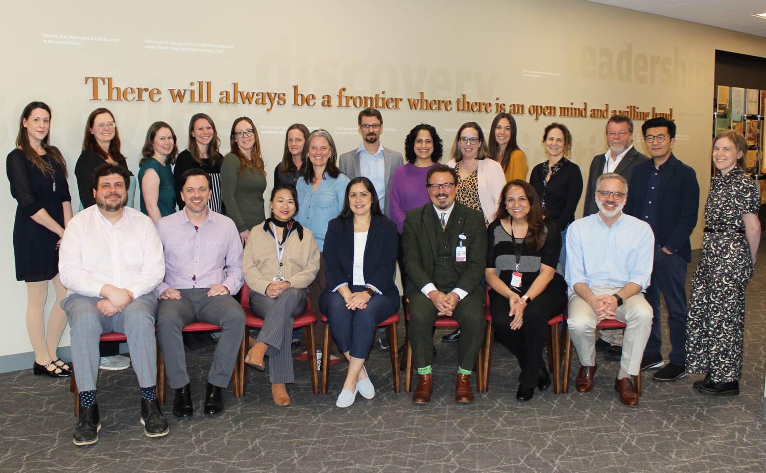 Department of Psychiatry research team posing for a group photo in a university building, with team members seated and standing in several rows.