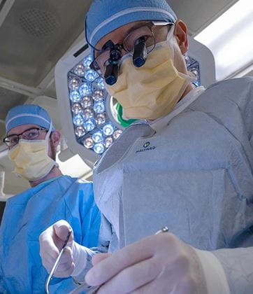 Dr. Kukbin Choi in operation room wearing surgical loops