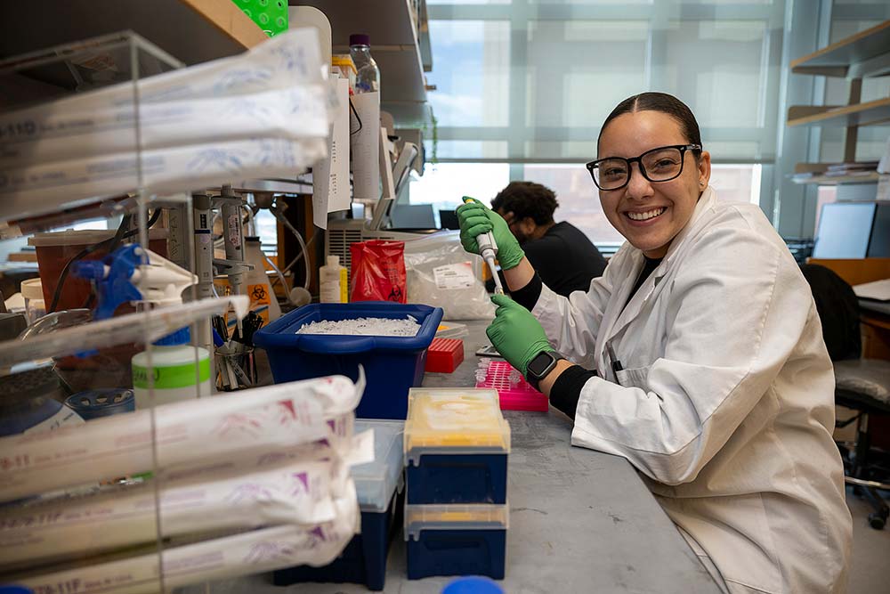 Student smiling while working in the lab