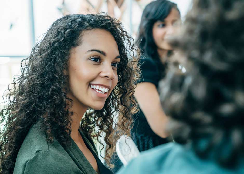 woman at a networking event smiling