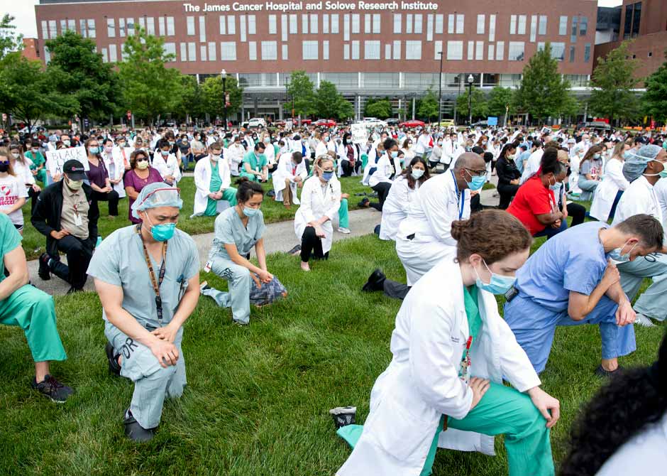 Medical staff kneeling outside