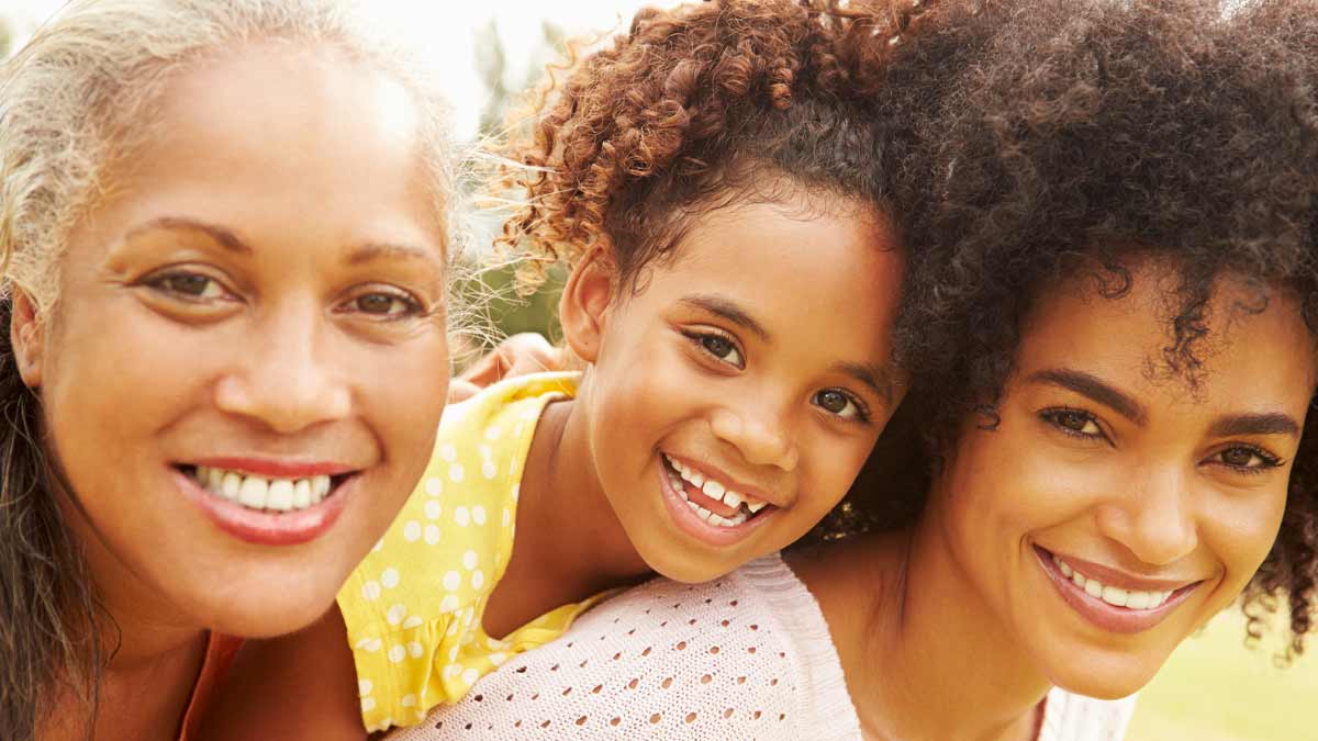Grandmother, mother and daughter smiling
