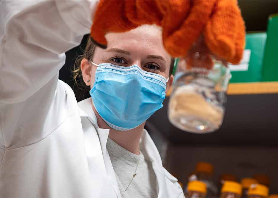 Researcher-holding-glass-vial