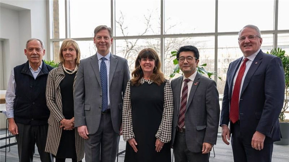 Four people stand next to K. Luan Phan and John J. Warner