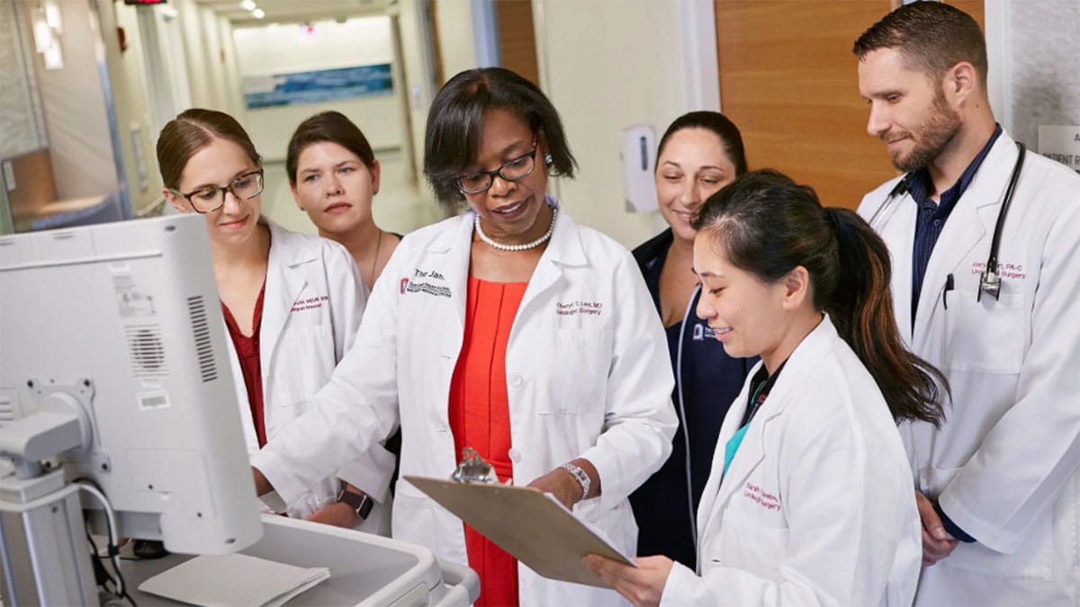 Doctors and nurses reviewing information on a clipboard.