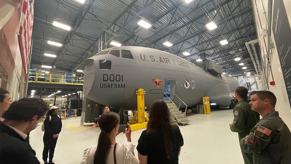 A group of students gathered around a jet plane at Wright Patterson Air Force Base.