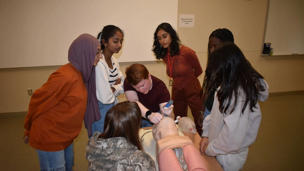 Image of students practicing on a manikin.