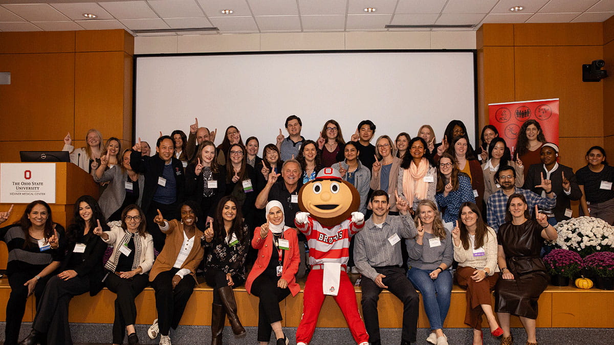 Image of a group of people sitting with Brutus Buckeye