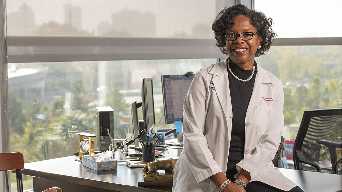 Image of Cheryl Lee sitting on a desk.