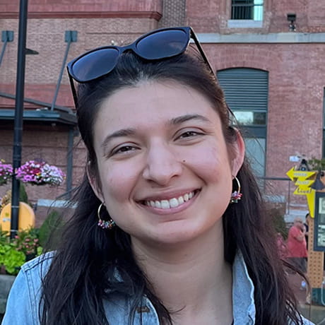 Headshot of Kairavee Thakkar out on the town with sunglasses on her head.