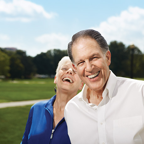 Husband and wife standing on Ohio State oval and laughing