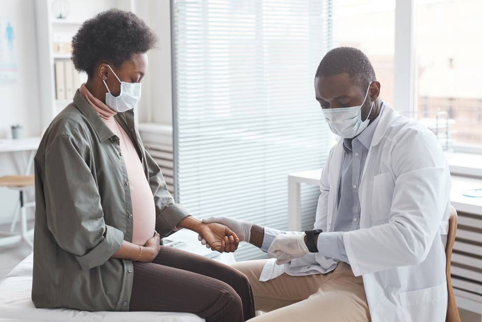 Doctor checks pulse of pregnant woman