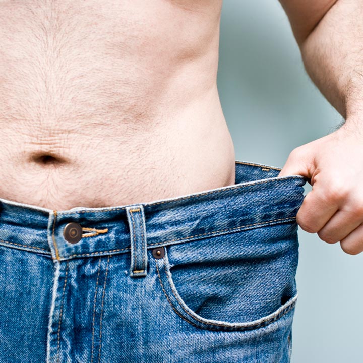 Man who recently lost weight tugging on jeans