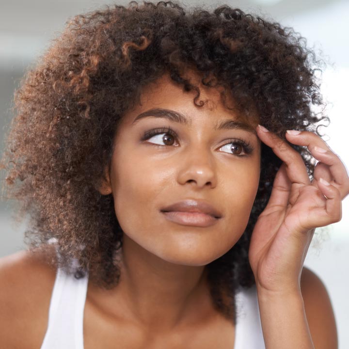 Young woman touching her eyebrows