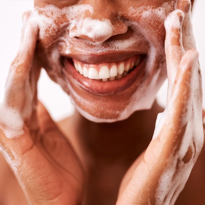Woman smiling and washing her face