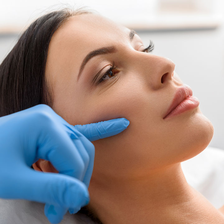 Woman having her face examined by a cosmetic surgeon